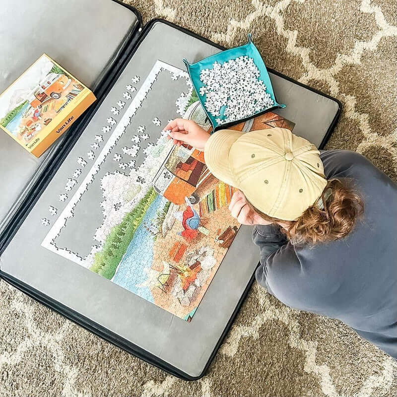 Person working on a puzzle with a box of puzzle pieces